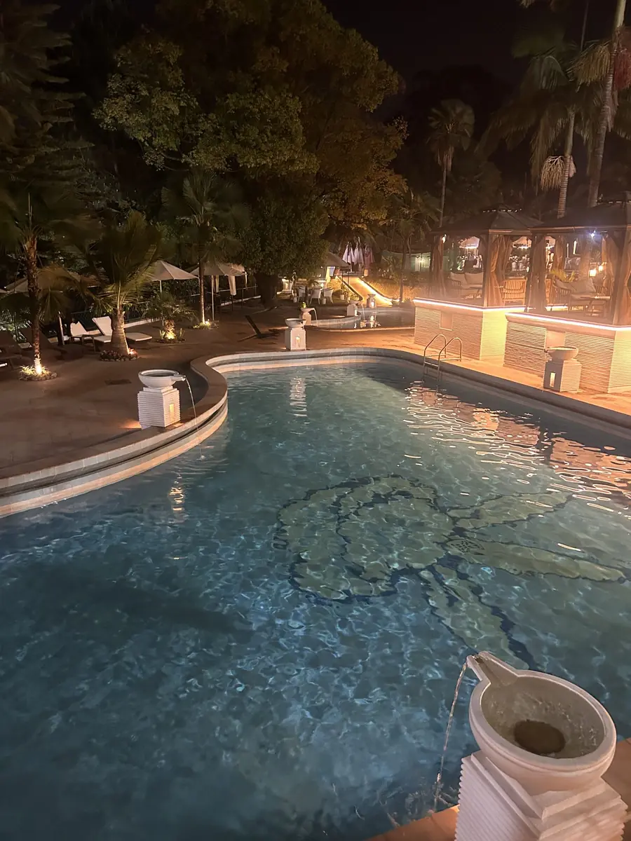 Resort pool glowing under evening lights